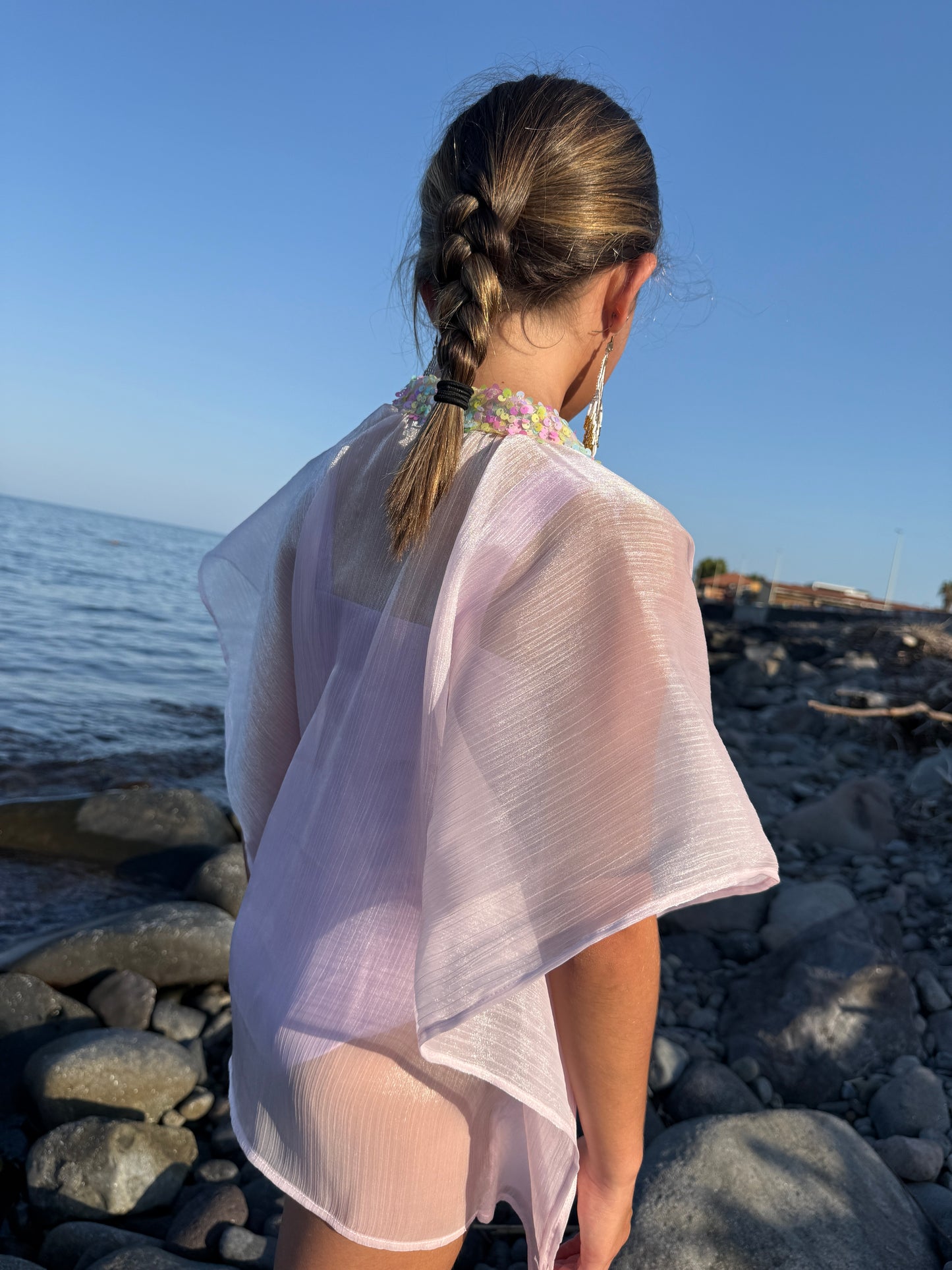 Side back view of girl in shimmery purple beach kaftan with light rainbow colored sequins along the neckline, sustainable beachwear for Dubai girls and kids