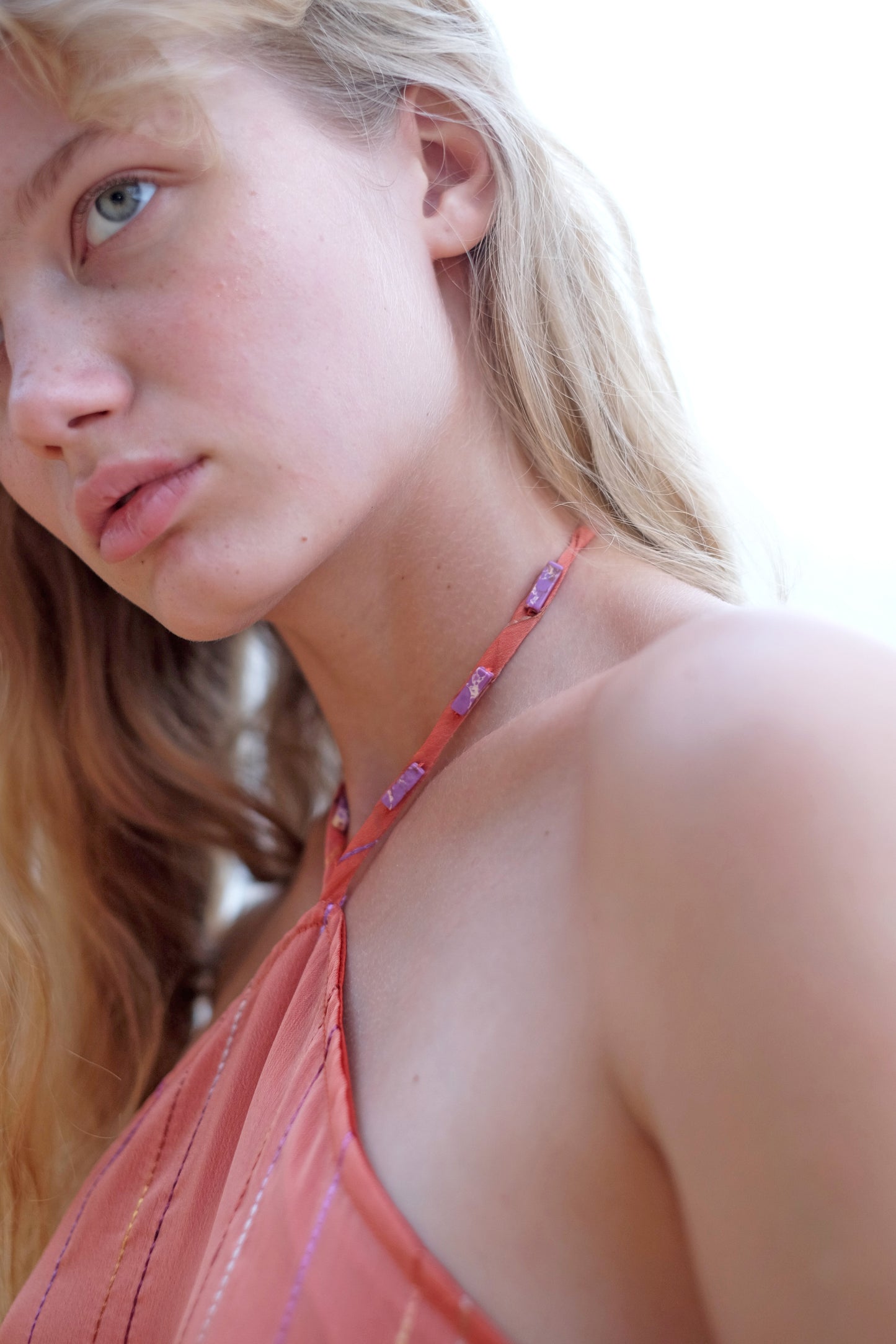 Close-up of the beadwork along the neckline of the Mimi burnt orange halter dress, adding a touch of elegance.
