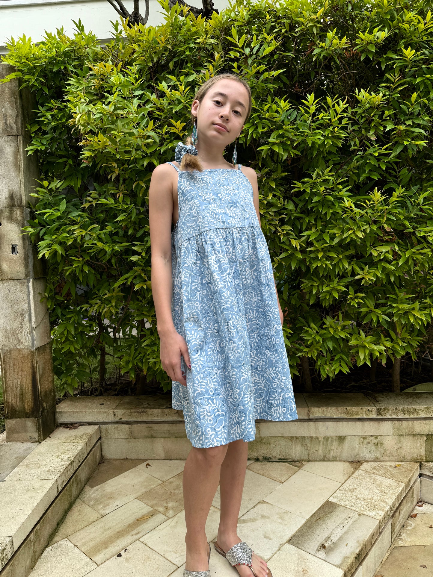 Handmade sustainable girls’ sundress in blue & white floral batik, ethically made in Bali, perfect for Dubai beach & summer wear.