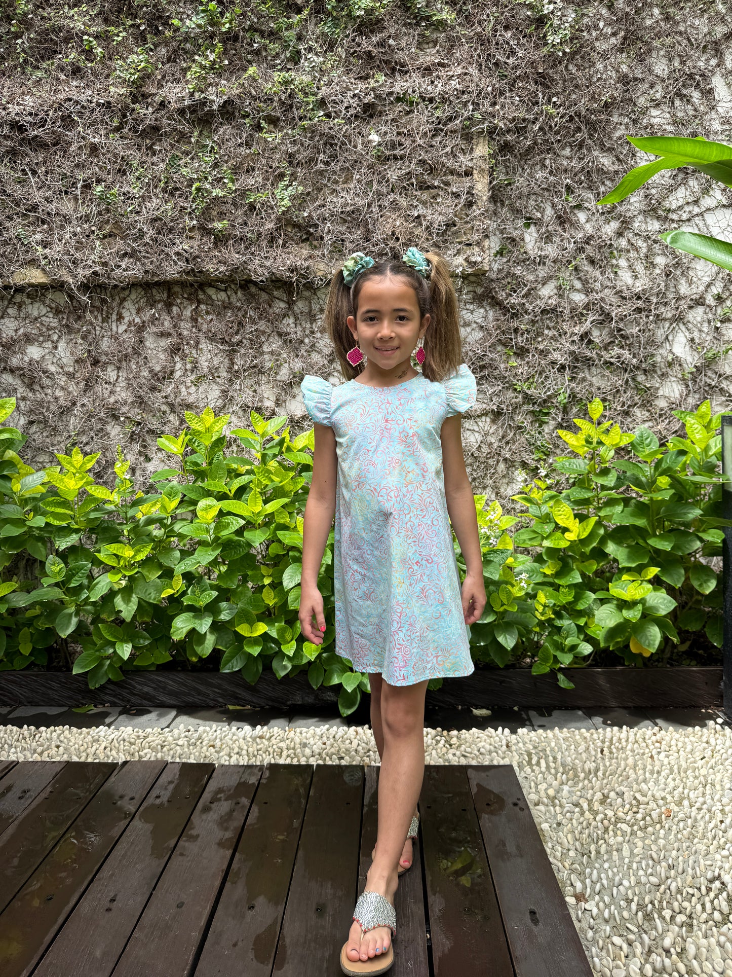 Ethical slow fashion kids dress handmade in Bali with hand-stamped batik cotton fabric, soft pastel blue a-line dress with ruffle sleeves, perfect for girls in Dubai