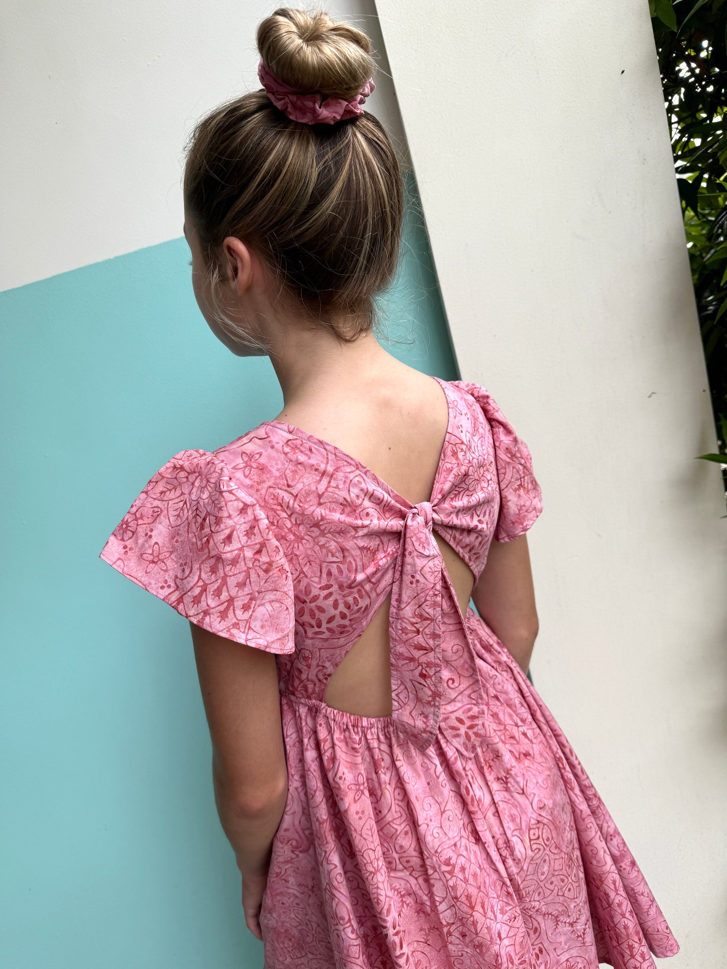 Ivy girls’ batik dress in pink floral, a lightweight, handcrafted kids’ sundress with a back tie for a perfect fit