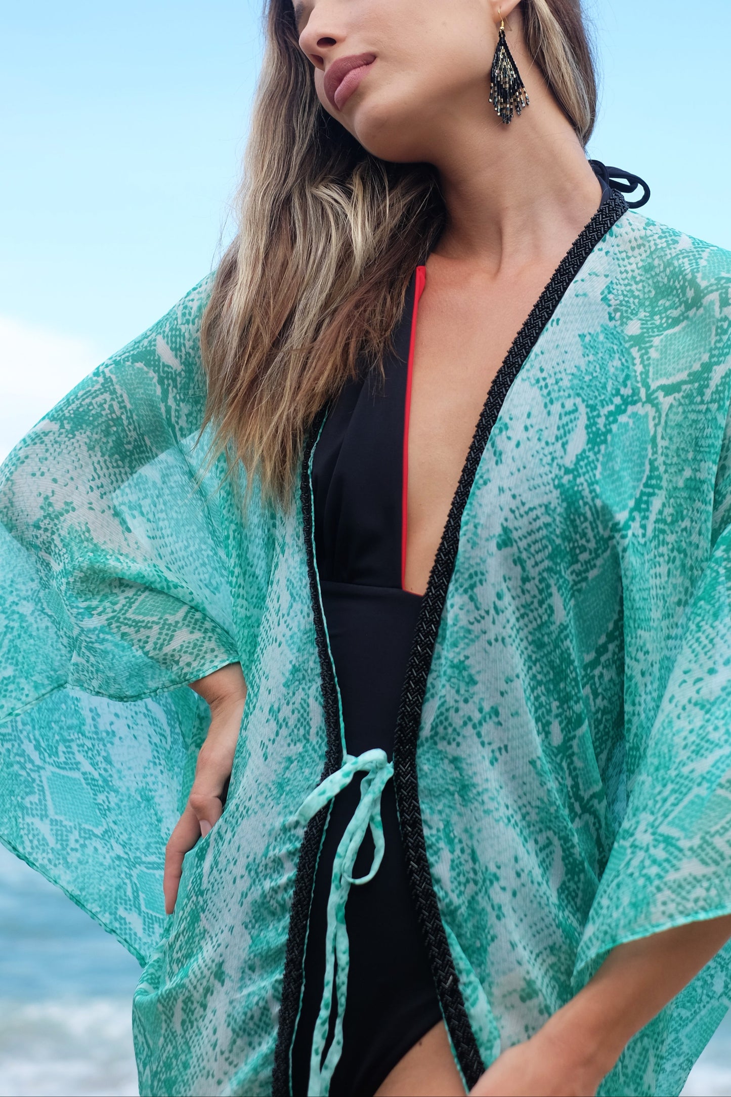 close up of the izara beach kaftan in green snake print chiffon and hand-sewn black beads, sustainable & ethical Dubai beachwear
