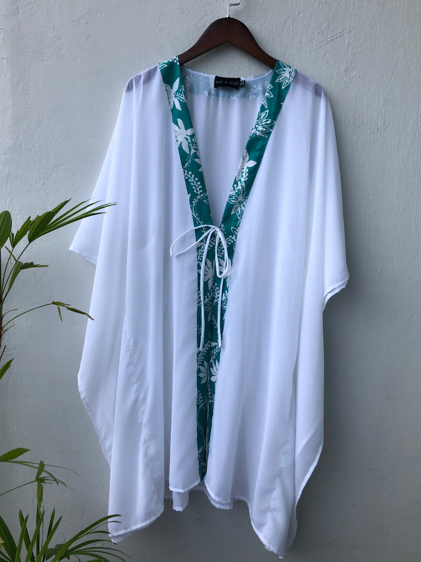 Ethically made white beach cover-up with hand-stamped green floral batik trim – perfect for Dubai vacations