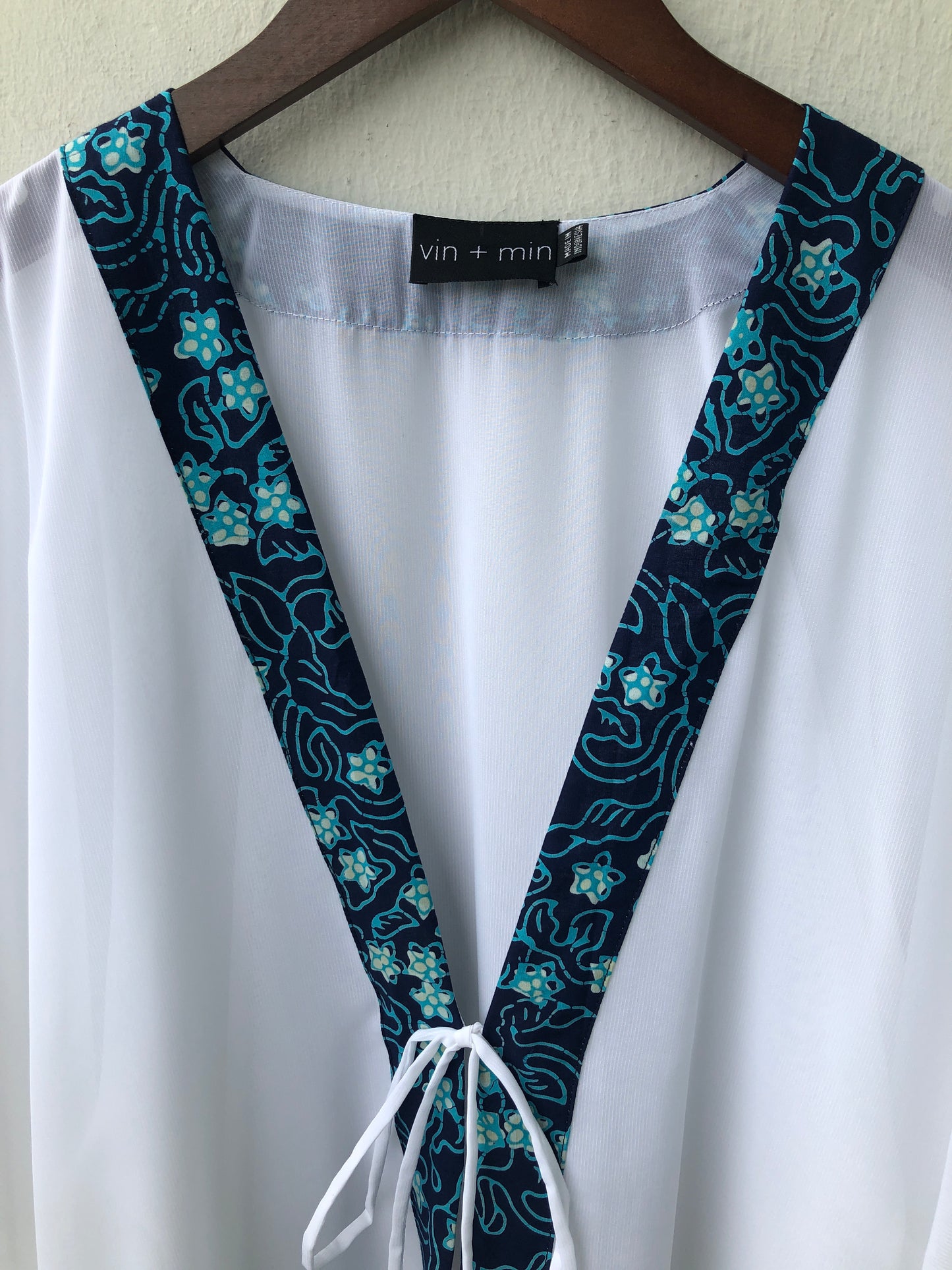 Sustainable handmade Onism women's beach kaftan in white lurex chiffon with artisan hand-stamped batik trim made in Indonesia, stylish and unique resort wear for Dubai