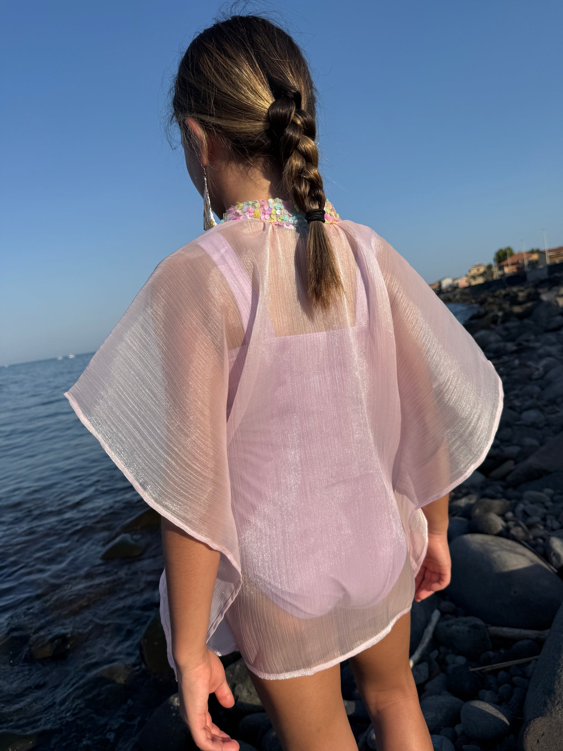 Close up back shot of girl in shimmery purple beach kaftan with light rainbow colored sequins along the neckline, beachwear for Dubai girls and kids