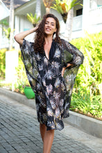 Load image into Gallery viewer, Alani women&#39;s black beach kaftan with black, white and gold palm leaves, and hand sewn black bead neckline trim, sustainable resort wear fashion made in Bali, available online in Dubai for women who love beach dresses and cover ups