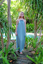 Load image into Gallery viewer, Young woman wearing a maxi length halter dress in yoryo chiffon featuring a pleated neckline and backline with beads and adjustable neckties