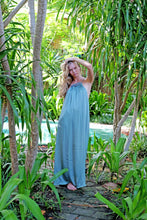 Load image into Gallery viewer, Full length shot of young woman wearing a maxi length halter dress in yoryo chiffon featuring a pleated neckline and backline with beads and adjustable neckties