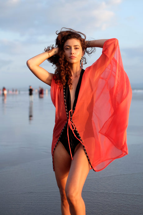 Elegant orange beach kaftan with hand-sewn metallic silver and black beaded neckline.
