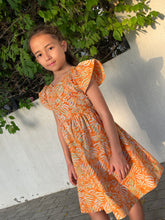 Load image into Gallery viewer, Ivy orange tiger lily cotton batik dress, handmade sustainably in Bali by local artisans, featuring ruffle sleeves, adjustable back ties, and an a-line fit, perfect for outings in Dubai!