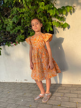 Load image into Gallery viewer, Ivy orange tiger lily cotton batik dress, handmade sustainably in Bali by local artisans, featuring ruffle sleeves, adjustable back ties, and an a-line fit, perfect for outings in Dubai and those who love slow fashion.