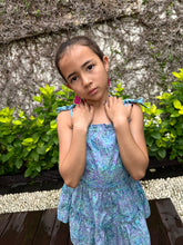Load image into Gallery viewer, Close up view of girls sundress for kids made from blue and purple artisan-made batik cotton fabric, shown from the back view, also wearing fuchsia handmade moroccan style earrings, handmade fashion in Bali, for young fashionistas in Dubai