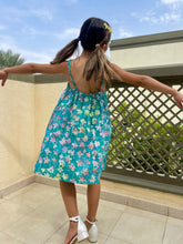 Load image into Gallery viewer, Back view of our Millie girls cotton dress made from green floral batik, artisan-made fabric from Indonesia, sustainably made fashion for girls in Dubai, featuring a-line fit, elastic waistband, and adjustable shoulder straps for perfect fit that grows with you child.