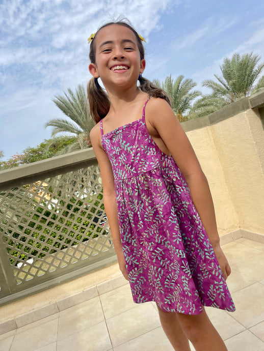 Millie kids sundress handmade by artisans in Bali, featuring hand-stamped cotton batik in bright purple and aquamarine, with adjustable waist and spaghetti straps, for fashion loving little ones in Dubai