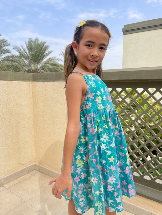 Millie girls cotton dress made from green floral batik, artisan-made fabric from Indonesia, sustainably made fashion for girls in Dubai, featuring a-line fit, elastic waistband, and adjustable shoulder straps for perfect fit that grows with you child.