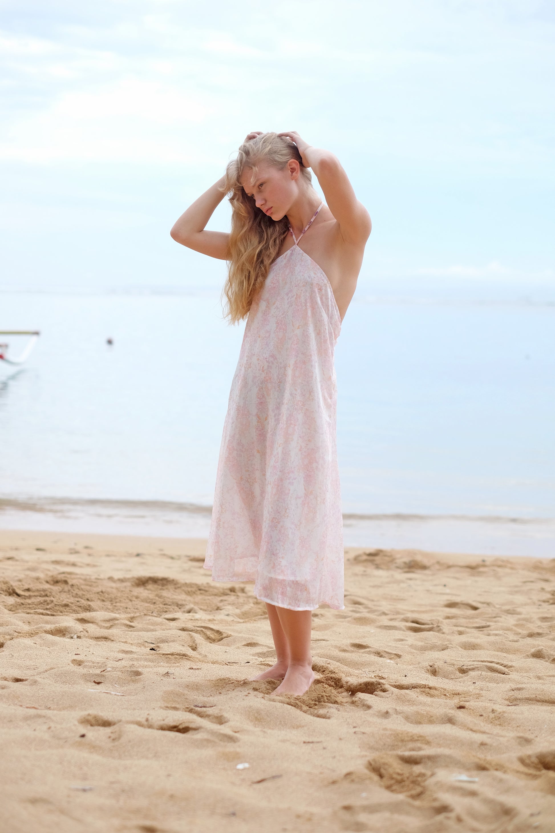 Model wearing the Mimi light pink floral halter dress, exuding a chic and feminine vibe for any casual outing.