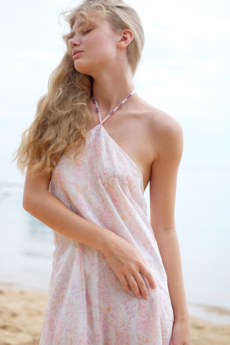 A close up front view of the Mimi midi halter dress in light pink floral print, showcasing its feminine design and flattering fit.
