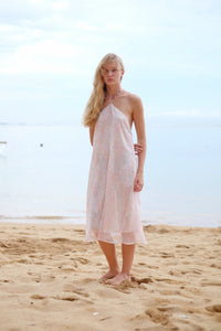 A front full length view of the Mimi midi halter dress in light pink floral print, showcasing its feminine design and flattering fit, sustainably made in Bali, perfect for adventures in Dubai