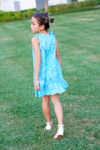 Back view of knee length Penelope Girls Batik Sundress in Blue Polka Dots, sustainably made in Bali. Hand-stamped batik, A-line silhouette, and adjustable ties. Perfect summer dress for girls in Dubai!