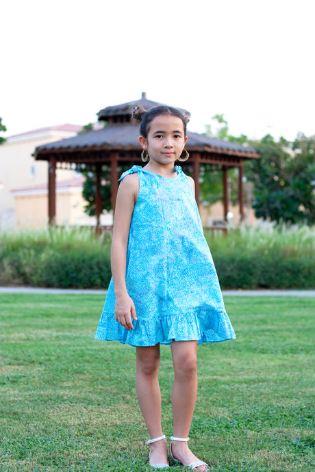 Shop the Penelope Girls Batik Sundress in Blue Polka Dots. Hand-stamped batik, A-line silhouette, and adjustable ties. Perfect summer dress for girls in Dubai!