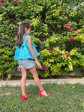 Load image into Gallery viewer, Back view photo of girl wearing light blue floral cotton batik top, with ruffles along neck and backlines, adjustable shoulder ties, can also be worn as skirt, handmade by artisans in Bali, available in Dubai