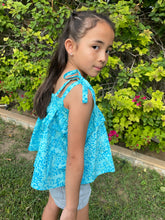 Load image into Gallery viewer, Close up photo of girl wearing light blue floral cotton batik top, with ruffles along neck and backlines, adjustable shoulder ties, can also be worn as skirt, handmade by artisans in Bali, available in Dubai