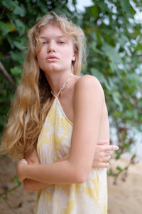 Adjustable yellow floral halter resort style dress with charming bead accents and a timeless fit, sustainably made in Bali for fashion lovers in Dubai