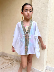 Stylish kids beach kaftan in white chiffon with sage pink batik trim, handmade in Bali, perfect for Dubai's warm climate and beach adventures
