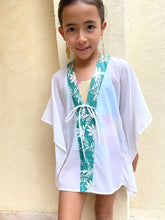 Load image into Gallery viewer, Handmade kids beach kaftan in white lurex chiffon with green floral batik trim – sustainable Dubai beachwear.
