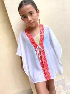 Handmade kids kaftan with vibrant orange floral batik trim, perfect for Dubai beach days