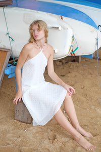 Elegant Mimi white midi beach dress with gold and silver metallic accents, styled for a casual resort beach day out in Dubai.