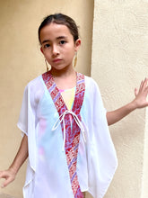 Load image into Gallery viewer, Stylish and breezy Onism Kids Beach Kaftan Cover Up in white lurex chiffon with artisan-crafted purple and burnt orange batik trim for resort stays in Dubai and beyond
