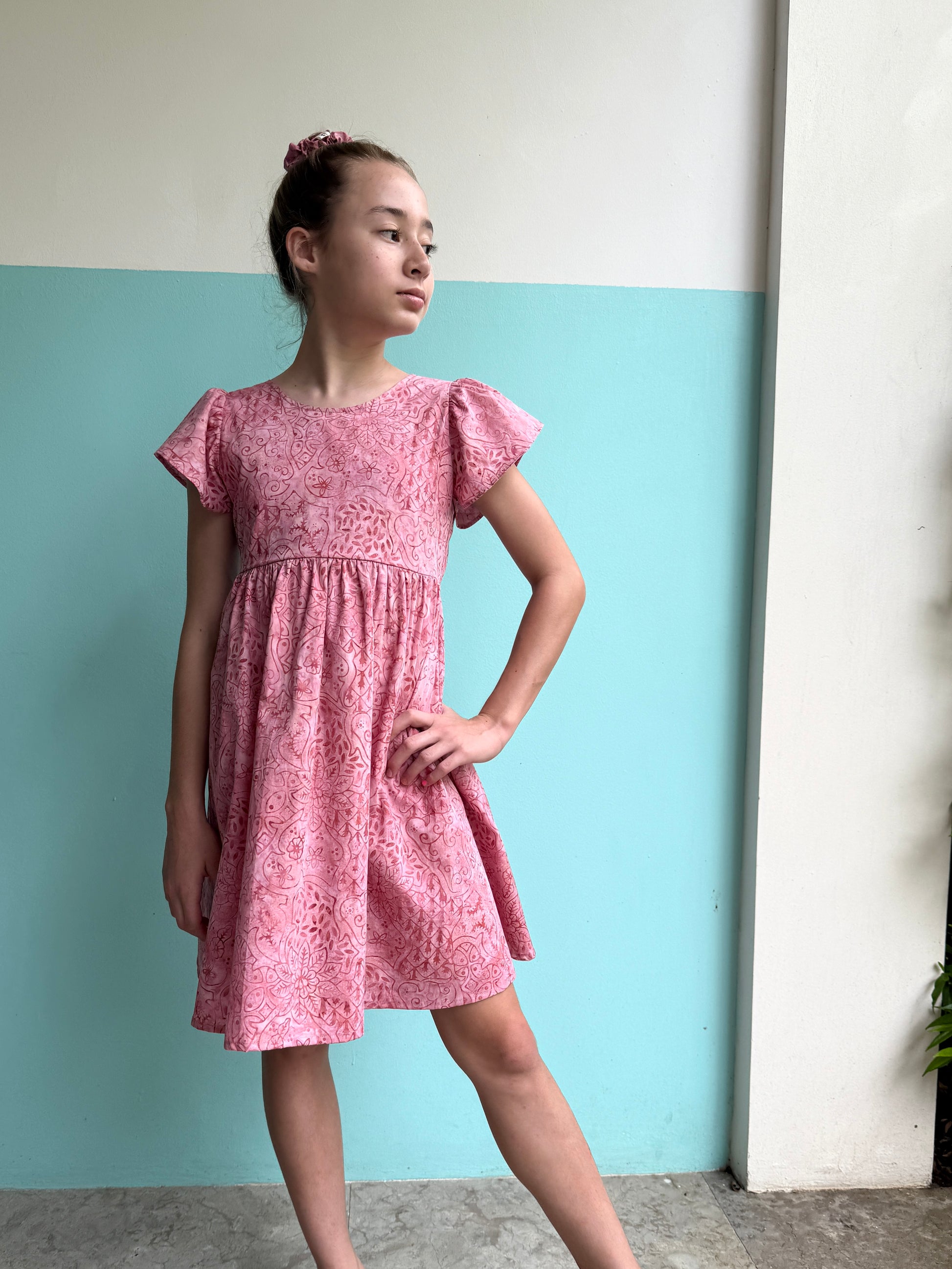 Ethically made girls’ pink floral batik sundress with adjustable back tie, perfect for beach days and warm-weather outings in Dubai
