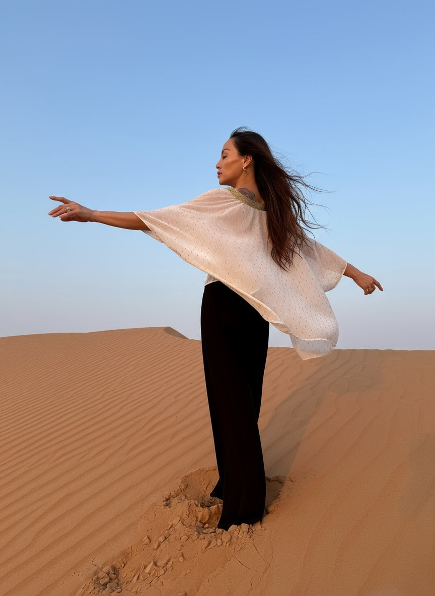 woman wearing white beach kaftan top in the desert in dubai