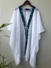Load image into Gallery viewer, Ethically &amp; sustainably made Onism sheer white beach kaftan with navy &amp; aqua floral batik detailing, flowy and breathable for tropical vacations,  handmade in Bali for sale in Dubai
