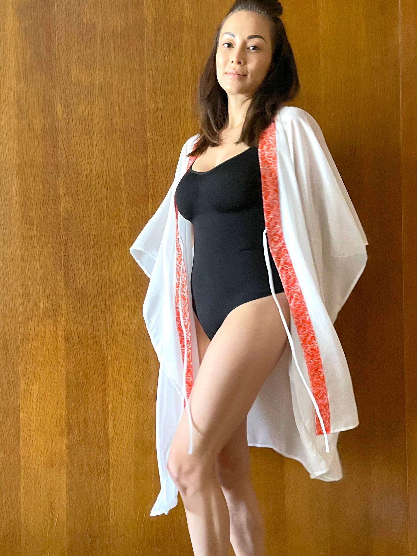Flowy and chic white kaftan with orange floral batik trim – perfect for tropical getaways
