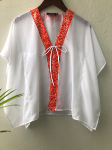 Eco-friendly kids beach kaftan with orange floral print, perfect for sunny Dubai vacations