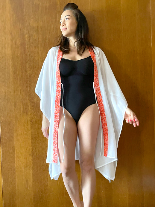 Onism Handmade white lurex chiffon beach kaftan for women with orange floral batik trim – perfect for Dubai resort wear
