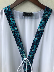 Sustainable handmade Onism women's beach kaftan in white lurex chiffon with artisan hand-stamped batik trim made in Indonesia, stylish and unique resort wear for Dubai
