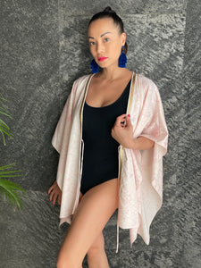 Luxurious satin Zahra kaftan in light pink paisley print, featuring gold-accented neckline trim for chic resort style in Dubai